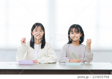 勉強しながらガッツポーズする二人の女の子 123835708