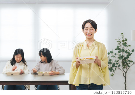 子どもにお弁当を提供する女性 子どもにお弁当を提供する女性 123835710