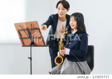サックス演奏を女子学生に指導する女性教師 サックス演奏を女子学生に指導する女性教師 123835717
