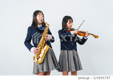 サックスとバイオリンを練習する女子学生グループ 123835737