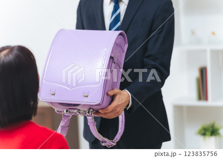 女の子にランドセルを渡す男性 女の子にランドセルを渡す男性 123835756