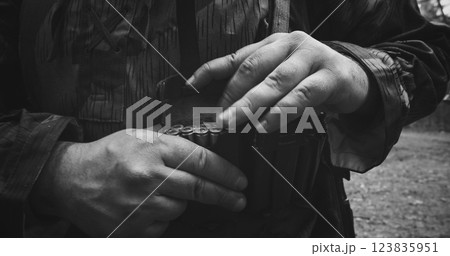 Reenactor Dressed As German Infantry Soldier Packing Chest Bandolier. Close-up View On Wermacht German Military Uniform During Ww2. Reenactment Tactic Game. Cartridge Belt Detail. Black And White 123835951