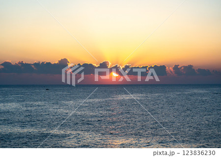 Sunset over the ocean, with the sun low on the horizon, contrast between sky and sea 123836230