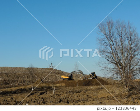 construction equipment working on a hill with earth, bulldozer and excavator leveling an earthen area on a hill, machines working on an industrial wasteland, heavy equipment preparing a site construction equipment working on a hill with earth, bulldozer and excavator leveling an earthen area on a hill, machines working on an industrial wasteland, heavy equipment preparing a site 123836445