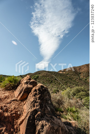 Scenic view of desert mountains and unique cloud formation under blue sky 123837240