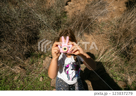 Child with pink toy camera outdoors in nature 123837279
