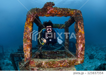 Male diver swimming through the artificial reef concrete block at Racha Yai Island in Phuket Male diver swimming through the artificial reef concrete block at Racha Yai Island in Phuket 123837354