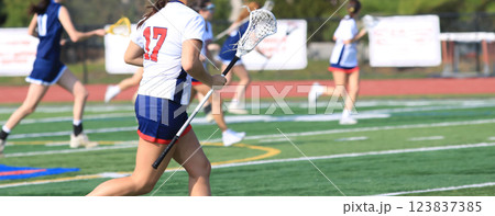 Female Lacrosse Players Engage in an Exciting Match on a Sunny Field 123837385