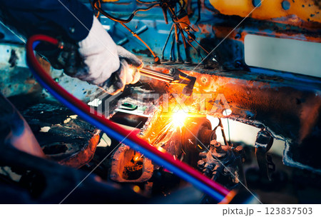 Close up hand heavy industrial worker is working on metal work factory process by Cutting sheet steel with gas cutting machine cutting thick steel in boilermakers workshop. 123837503
