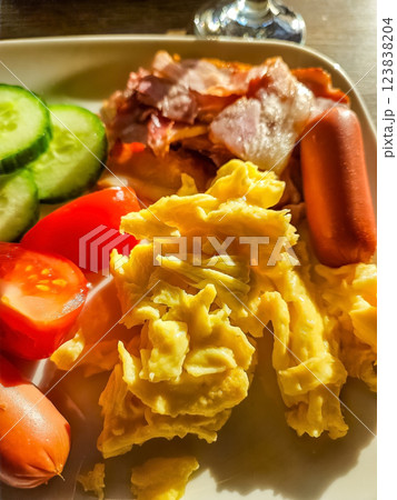 Scrambled Eggs, Crispy Bacon, Sausages, and Fresh Vegetables on White Plate. High quality photo Scrambled Eggs, Crispy Bacon, Sausages, and Fresh Vegetables on White Plate. High quality photo 123838204