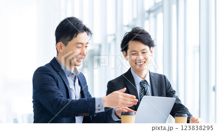 パソコンを使って打ち合わせをする2人の男性ビジネスマン パソコンを使って打ち合わせをする2人の男性ビジネスマン 123838295