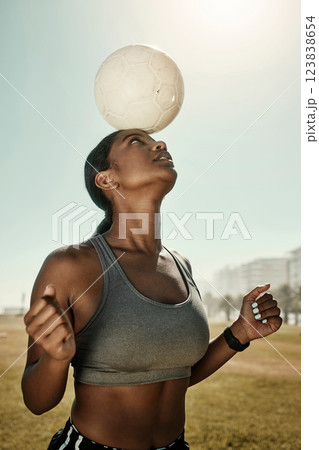 Woman, soccer ball and balance on head in training grass field, sports ground or fitness training club. Football player, black woman and athlete in exercise practice with wellness goals or motivation 123838654