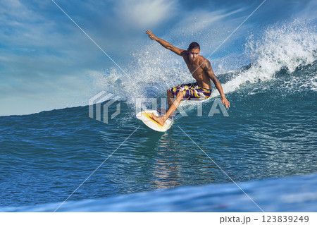 Male surfer on a blue wave 123839249