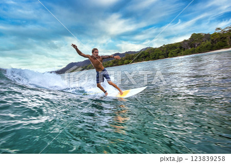 Male surfer on a blue wave 123839258