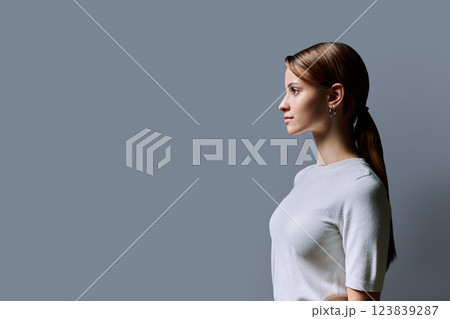 Profile portrait of young teenage girl, gray studio copy space background 123839287