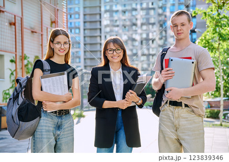 Portrait female teacher with teenagers students, outdoor, college building background 123839346