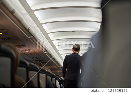 Passenger seat, the interior of an airplane with passengers sitting on the seats. An unrecognizable stewardess is serving tea. The concept of travel. High quality photo Passenger seat, the interior of an airplane with passengers sitting on the seats. An unrecognizable stewardess is serving tea. The concept of travel. High quality photo 123839521