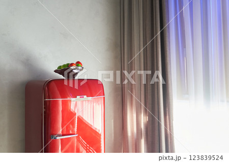 One red refrigerator on the background of a light wall near the window. With space to copy. High quality photo One red refrigerator on the background of a light wall near the window. With space to copy. High quality photo 123839524