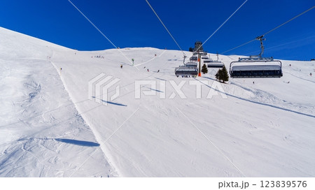 Skiing down a snow-covered mountainside in the beautiful Alps of Austria on a sunny winter day. 123839576