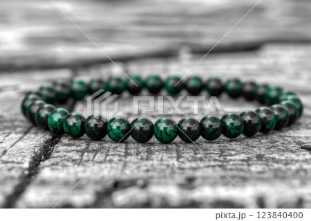 Stylish black and green bead bracelet on wooden table 123840400