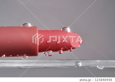 Classic lipstick with drops of water on a neutral background. 123840456