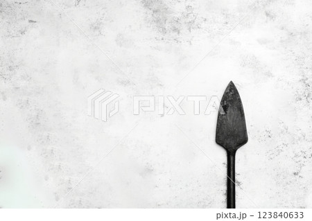 Simple black garden spade on a textured background 123840633