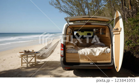 White van parked at a remote beach with a surfboard leaning on it 123841055