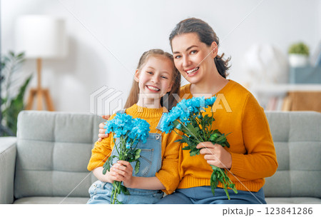 daughter is congratulating mom and giving her flowers daughter is congratulating mom and giving her flowers 123841286