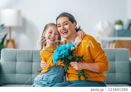 daughter is congratulating mom and giving her flowers daughter is congratulating mom and giving her flowers 123841306