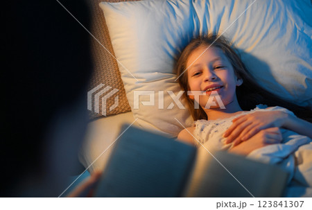 mother reading a book to her daughter mother reading a book to her daughter 123841307