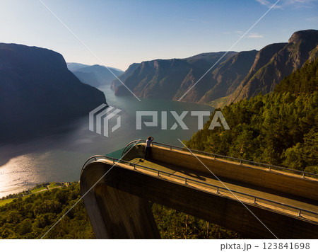 Tourist enjoying fjord view on Stegastein viewpoint Norway Tourist enjoying fjord view on Stegastein viewpoint Norway 123841698