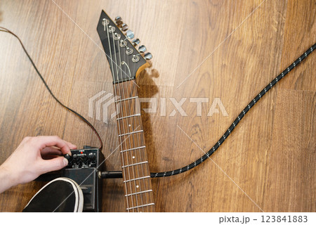Man adjusting guitar effects pedal Man adjusting guitar effects pedal 123841883