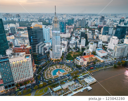 beautiful sunset over Ho Chi Minh city skyline and Saigon river, green tropical park and financial downtown district with tall skyscraper towers, Vietnam aerial drone view 123842280