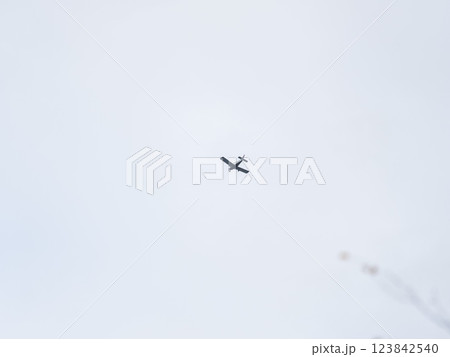 Small ultralight airplane with overhead wing and single propeller flying in sunset sky. Small ultralight airplane with overhead wing and single propeller flying in sunset sky. 123842540