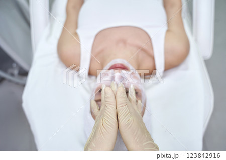 Female receiving facial treatment in spa setting for skin care relaxation 123842916