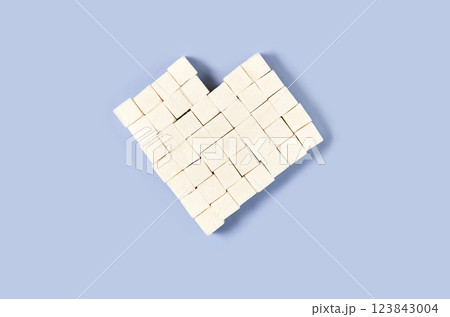 Heart shaped sugar cubes arranged on light blue background creating sweet love 123843004