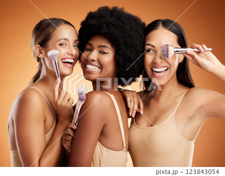 Makeup, beauty and women with brush for cosmetics against a brown mockup studio background. Face portrait of happy, smile and young model group with product for facial foundation and skincare 123843054