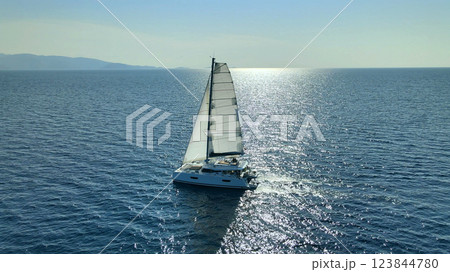 Catamaran Yacht Under Sail Moving On Open Sea At Sunset  123844780