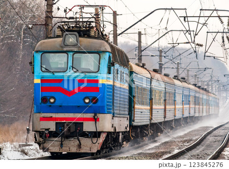 Passenger train rapidly moving along snow covered tracks in Kyiv Oblast of Ukraine 123845276