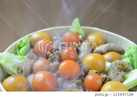 湯気の立ち昇る蒸籠で鶏モツを蒸す 湯気の立ち昇る蒸籠で鶏モツを蒸す 123847186