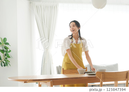 食器を片付けるエプロンの女性 123847394