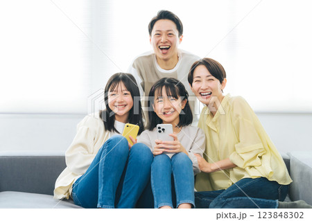 笑顔でスマホを持つ小学生の女の子の家族 123848302