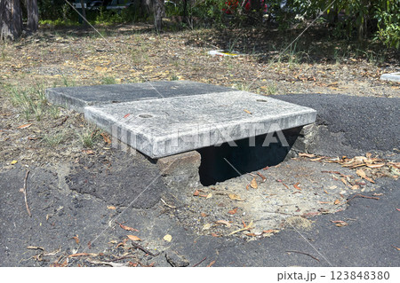 An old concrete water drain located near a road An old concrete water drain located near a road 123848380