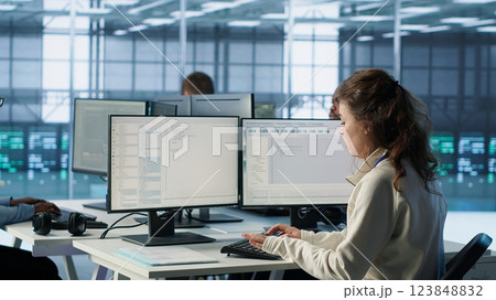 Manager supervising multiethnic team working in data center, making announcement. Team leader discussing with employees monitoring energy consumption across server rigs components, camera A 123848832