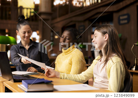 Tutor providing accurate learning materials during academic session with schoolgirls, promoting child development in supportive private lessons. Mentor boosts knowledge with library resources. Tutor providing accurate learning materials during academic session with schoolgirls, promoting child development in supportive private lessons. Mentor boosts knowledge with library resources. 123849099