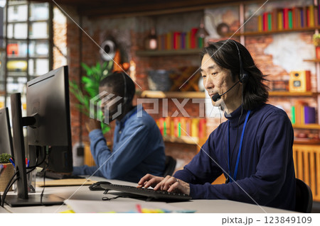 Team of call center agents cooperating to provide step by step guidance to customers, talking in headset mic. Coworkers doing customer support job working together, walking clients through fixes 123849109