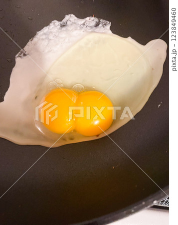 Double yolked egg broken open in pan frying Double yolked egg broken open in pan frying 123849460