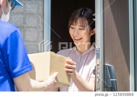 荷物を受け取る女性 配達員 受け取り 荷物を受け取る女性 配達員 受け取り 123850868
