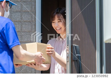 荷物を受け取る女性 配達員 受け取り 荷物を受け取る女性 配達員 受け取り 123850992
