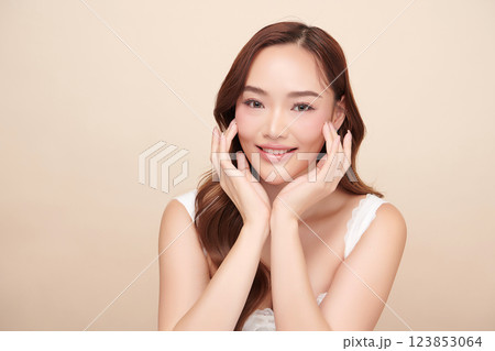 A beautiful young Asian woman with clean, fresh skin against a beige background. She represents beauty, skincare, and spa treatments. A beautiful young Asian woman with clean, fresh skin against a beige background. She represents beauty, skincare, and spa treatments. 123853064